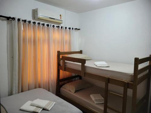 ポメロデにあるEspaço Wunder Platzの二段ベッド2台とカーテンが備わる客室です。