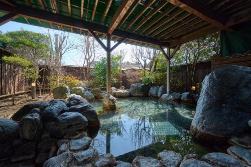 a pool of water with rocks in a yard at Royal Hotel Kawaguchiko in Fujikawaguchiko
