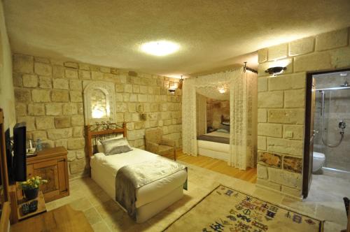 a bedroom with a bed and a bathroom with a shower at Goreme Inn Hotel in Göreme