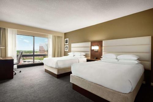 a hotel room with two beds and a large window at DoubleTree by Hilton Orlando Downtown in Orlando