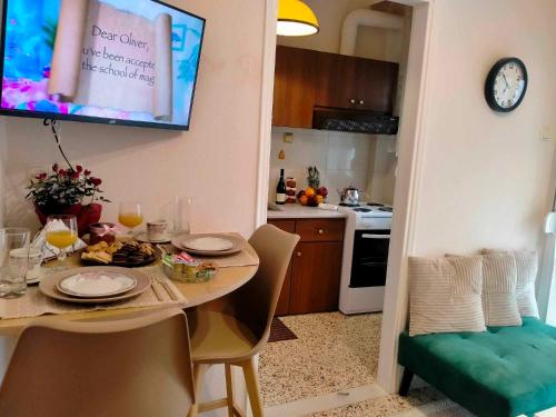 a kitchen with a dining room table and a television at 2BDR Downtown Veria Peach Blossom in Veria