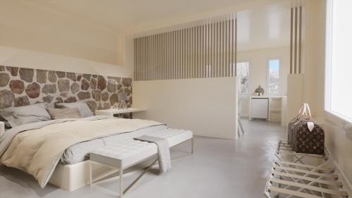 Un dormitorio blanco con una cama grande y un banco en Eolithos Suites en Éxo Goniá