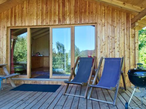 two chairs on the deck of a log cabin at Berg-Chalet im Glamping-Paradies auf dem Dengler Hof in Hohenberg an der Eger