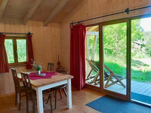 a dining room with a table and a sliding glass door at Berg-Chalet im Glamping-Paradies auf dem Dengler Hof in Hohenberg an der Eger