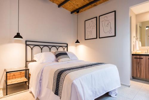 - une chambre avec un grand lit et des draps blancs dans l'établissement Casa Murmullos, à Guadalajara
