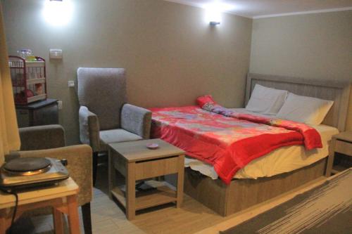 a bedroom with a bed and a chair and a table at Elgouna in Hurghada