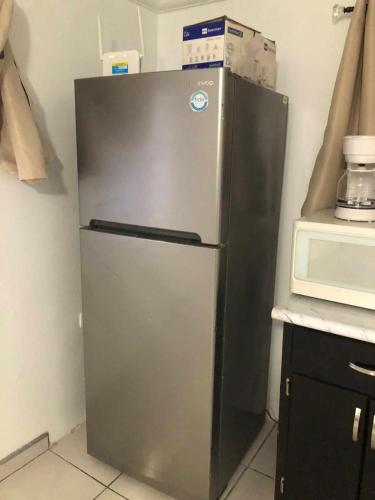 a silver refrigerator in a kitchen next to a microwave at Casa Peninsula in San Felipe