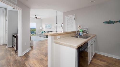 a kitchen with a sink and a living room at Luau I 6708 in Destin