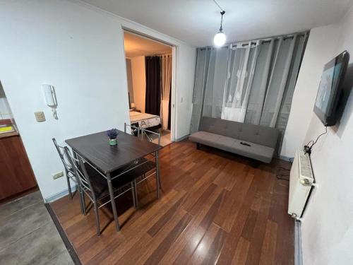 a living room with a table and chairs and a television at Alojamiento Santiago Centro in Santiago