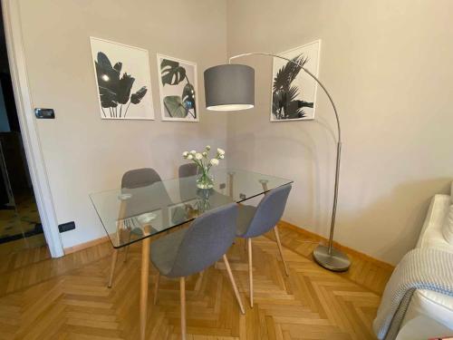 - une table en verre avec des chaises et une lampe dans la chambre dans l'établissement Urban Jungle apt - Self Check-in, Metro, Train, à Turin