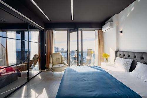 a bedroom with a large bed and a balcony at Apartments Beach Tower in Batumi