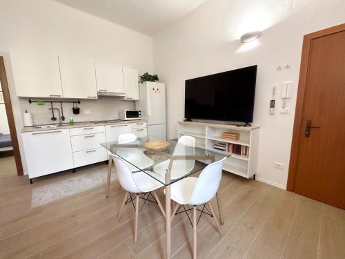 a kitchen with a glass table and white cabinets at La Casa di Leo Apartments in San Giorgio di Piano