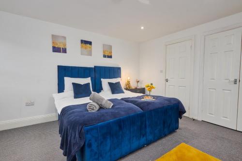 里茲的住宿－NEW! Perfect for Families & Corporates - 3 Beds - Contact us for Better Offers!，一间卧室配有蓝色的床和蓝色的毯子