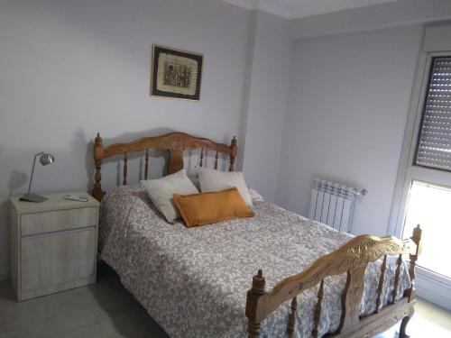 a bedroom with a bed and a lamp and a window at Dpto Alberdi in Santa Fe