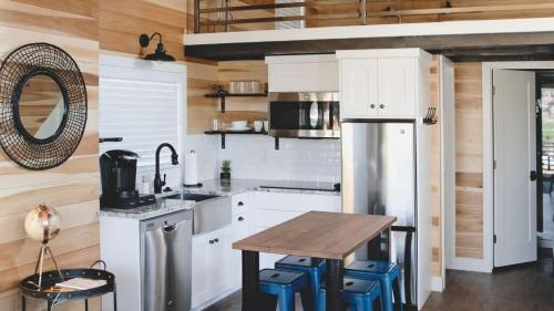a kitchen with white cabinets and a wooden wall at Escalante Escapes Desert Willow- Loft Escape in Escalante