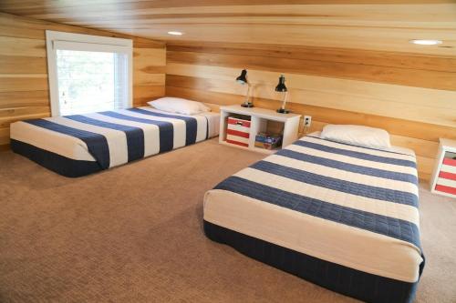 2 camas en una habitación con paredes de madera en Escalante Escapes Desert Willow- Loft Escape en Escalante