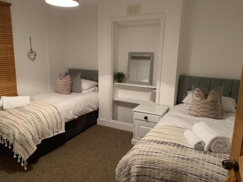 - une chambre avec 2 lits et un miroir dans l'établissement ⭐️Sleeps 4/Longstays/Garden/Parking/WiFi⭐️, à Crawley