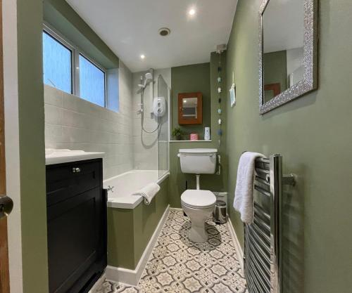 La salle de bains verte est pourvue de toilettes et d'un lavabo. dans l'établissement ⭐️Sleeps 4/Longstays/Garden/Parking/WiFi⭐️, à Crawley
