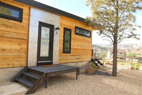 uma casa de madeira com um banco em frente em Escalante Escapes Tumble Weed- Bunk Escape em Escalante