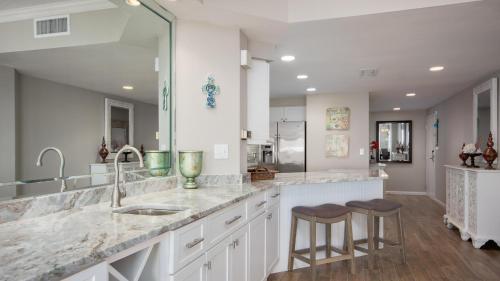 a kitchen with a sink and two bar stools at Westwinds 4848 Su in Destin