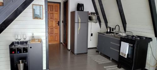 Il comprend une cuisine équipée d'un réfrigérateur et d'une cuisinière. dans l'établissement Chale Brisa Do Mar, à Palhoça