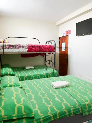 a bedroom with two bunk beds and a flat screen tv at Luz de Aurora HOTEL in Manta