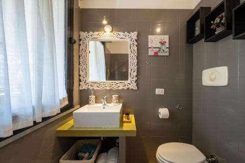 a bathroom with a sink and a mirror and a toilet at Elegante Villa Lu' centro Città a 10 minuti dal mare in Cagliari