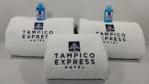 drei Stapel Handtücher auf einem Tisch in der Unterkunft HOTEL TAMPICO EXPRESS MORALILLO in Tampico