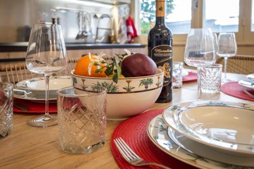 a table with a bowl of fruit and a bottle of wine at Elegante Villa Lu' centro Città a 10 minuti dal mare in Cagliari