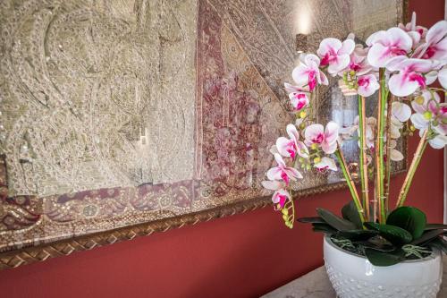 a vase with flowers in it next to a painting at Elegante Villa Lu' centro Città a 10 minuti dal mare in Cagliari