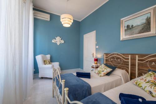 a bedroom with two beds and a blue wall at Elegante Villa Lu' centro Città a 10 minuti dal mare in Cagliari