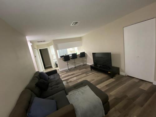a living room with a couch and a flat screen tv at Private room. 5 mins from Freemont. 10 mins from strip in Las Vegas