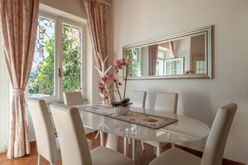 a dining room with a table and chairs and a window at Elegante Villa Lu' centro Città a 10 minuti dal mare in Cagliari