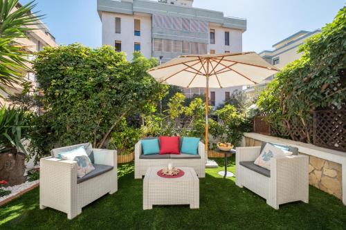 a patio with two chairs and an umbrella at Elegante Villa Lu' centro Città a 10 minuti dal mare in Cagliari