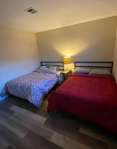 1 dormitorio con 2 camas y manta roja en Private room. 5 mins from Freemont. 10 mins from strip, en Las Vegas
