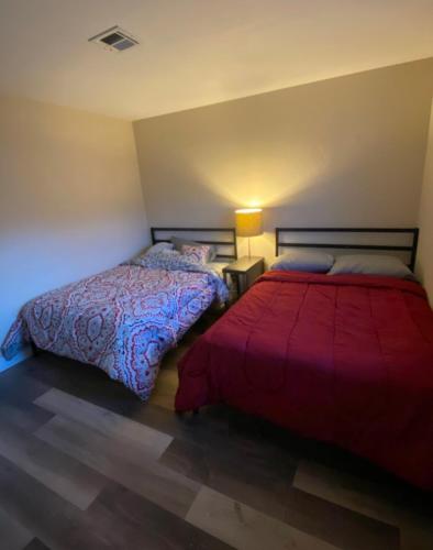 a bedroom with two beds and a red blanket at Private room. 5 mins from Freemont. 10 mins from strip in Las Vegas