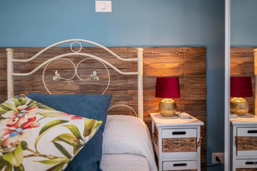 a bedroom with a bed with two night stands and two lamps at Elegante Villa Lu' centro Città a 10 minuti dal mare in Cagliari
