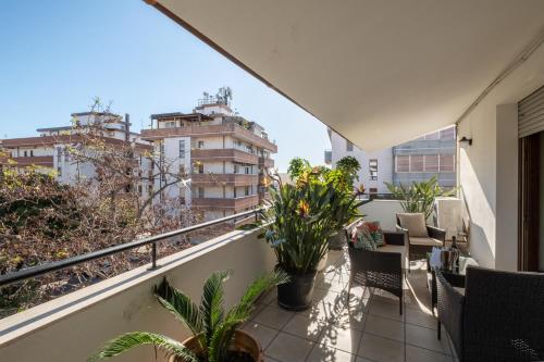 a balcony with chairs and plants on a building at Elegante Villa Lu' centro Città a 10 minuti dal mare in Cagliari