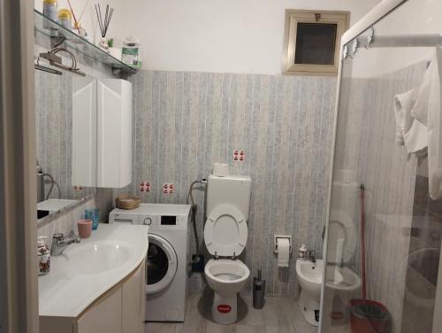 Appartamento in Garfagnana في كاستيلنيوفو دي غارفانيانا: حمام مع مرحاض ومغسلة وغسالة
