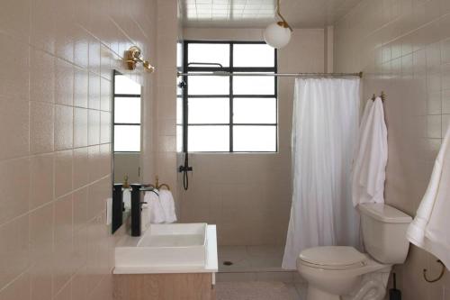 ein weißes Bad mit einem WC und einem Fenster in der Unterkunft 204 Beautiful spacious 2BR/2B Polanco´s best area in Mexiko-Stadt