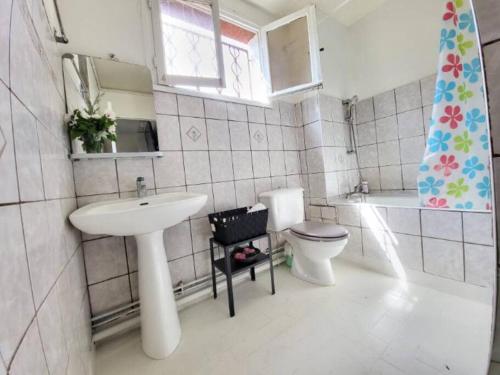 une salle de bain avec un lavabo et des toilettes et une fenêtre dans l'établissement Logement entier proche de paris, à Rosny-sous-Bois