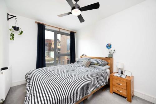 a bedroom with a bed and a ceiling fan at Chic 1BR London Flat with Balcony and Garden Access in London