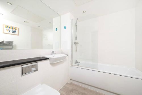 a bathroom with a toilet and a sink and a shower at Chic 1BR London Flat with Balcony and Garden Access in London