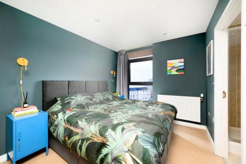 a bedroom with a bed and a blue wall at Cozy and modern 1BR flat in Enfield in Enfield