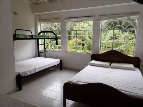 een kamer met 2 stapelbedden en 2 ramen bij LA CASA DE TURRIN in Anapoima