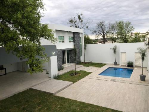ein weißes Haus mit einem Pool im Hof in der Unterkunft Quinta Felinos in Allende