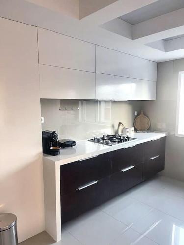 uma cozinha com armários brancos e um forno com placa de fogão em Le Privée 1 em Mindelo