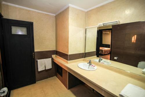 Hotel Jedda douhi el ouassini في وجدة: حمام مع حوض ومرآة