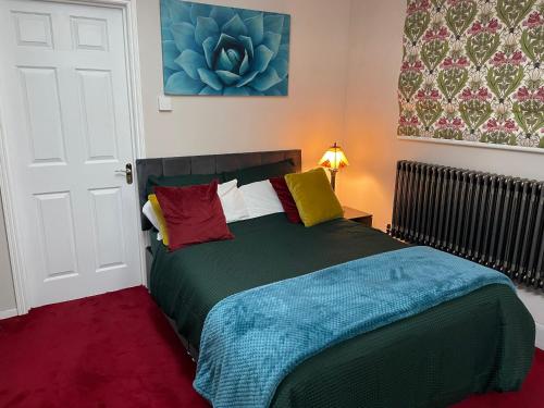 a bedroom with a green bed with colorful pillows at Stylish Home Away From Home in Kent with Easy Access to London! in Wrotham