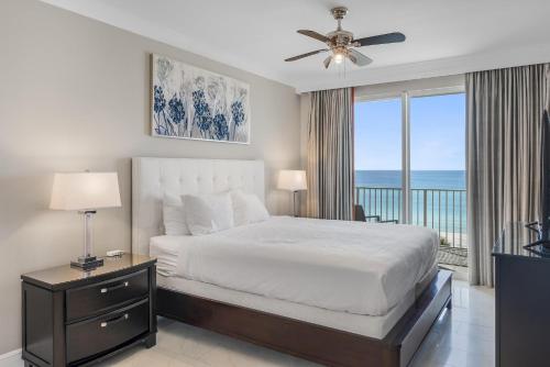 a bedroom with a bed and a balcony with the ocean at Majestic Sun 414B in Destin